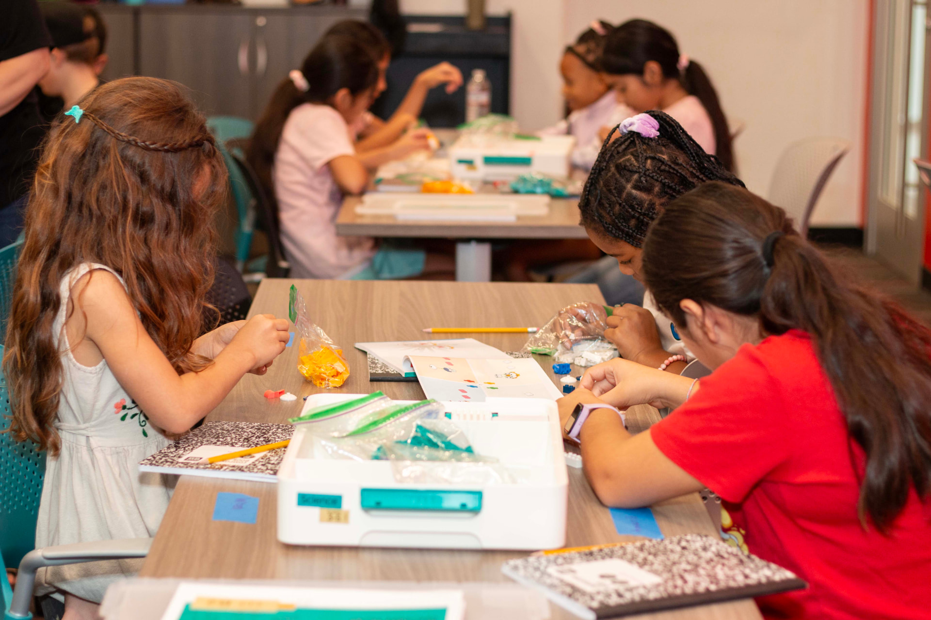 Small teams of students building LEGO science models