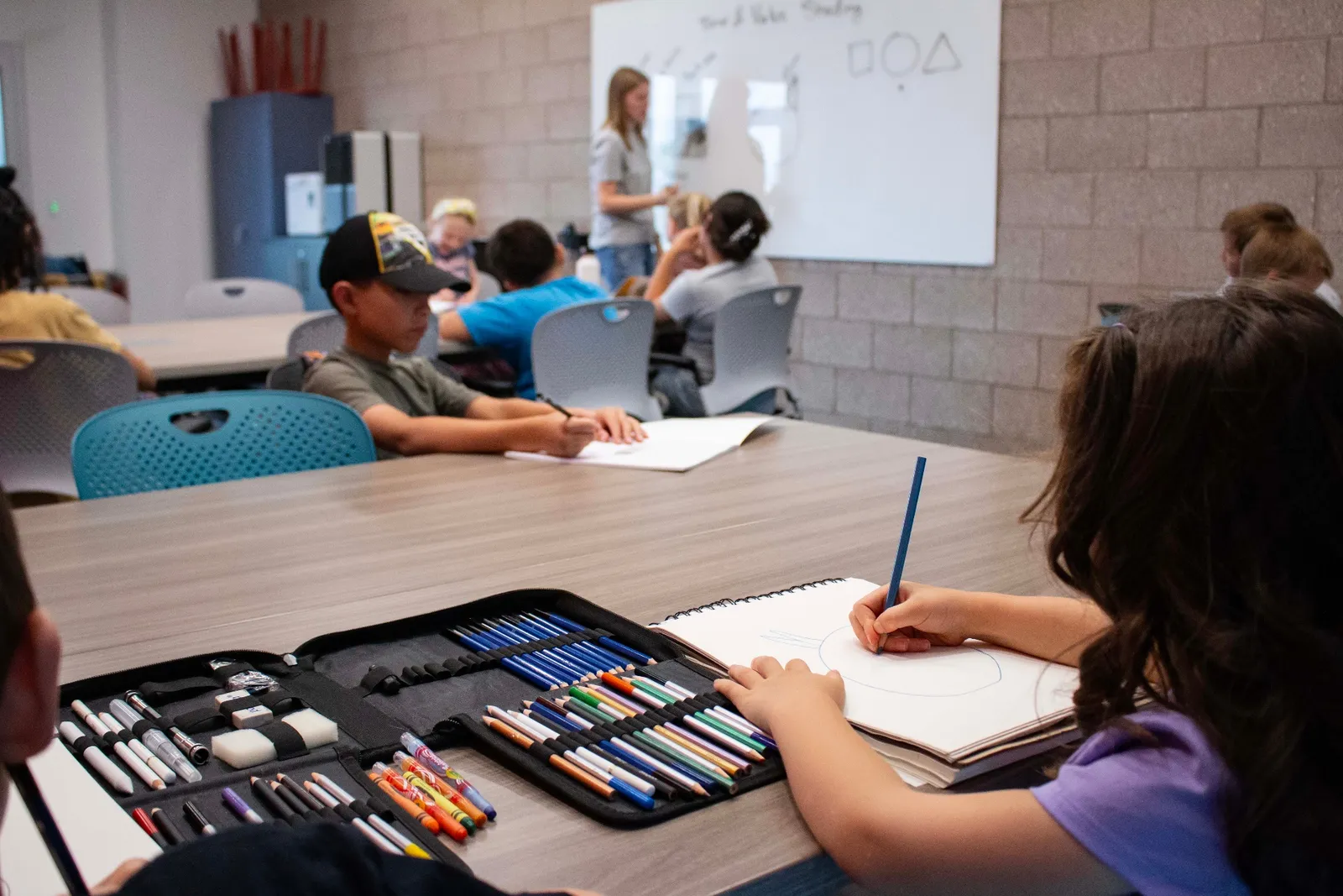 Sanctuary Art Program student sketching with colored pencils
