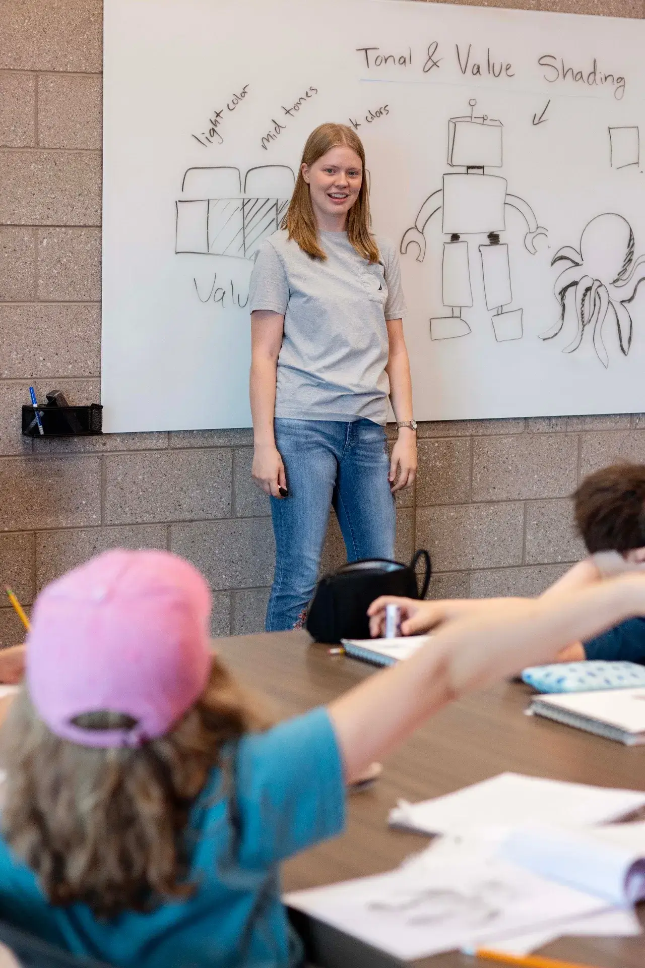 Instructor teaching a group of kids at a whiteboard