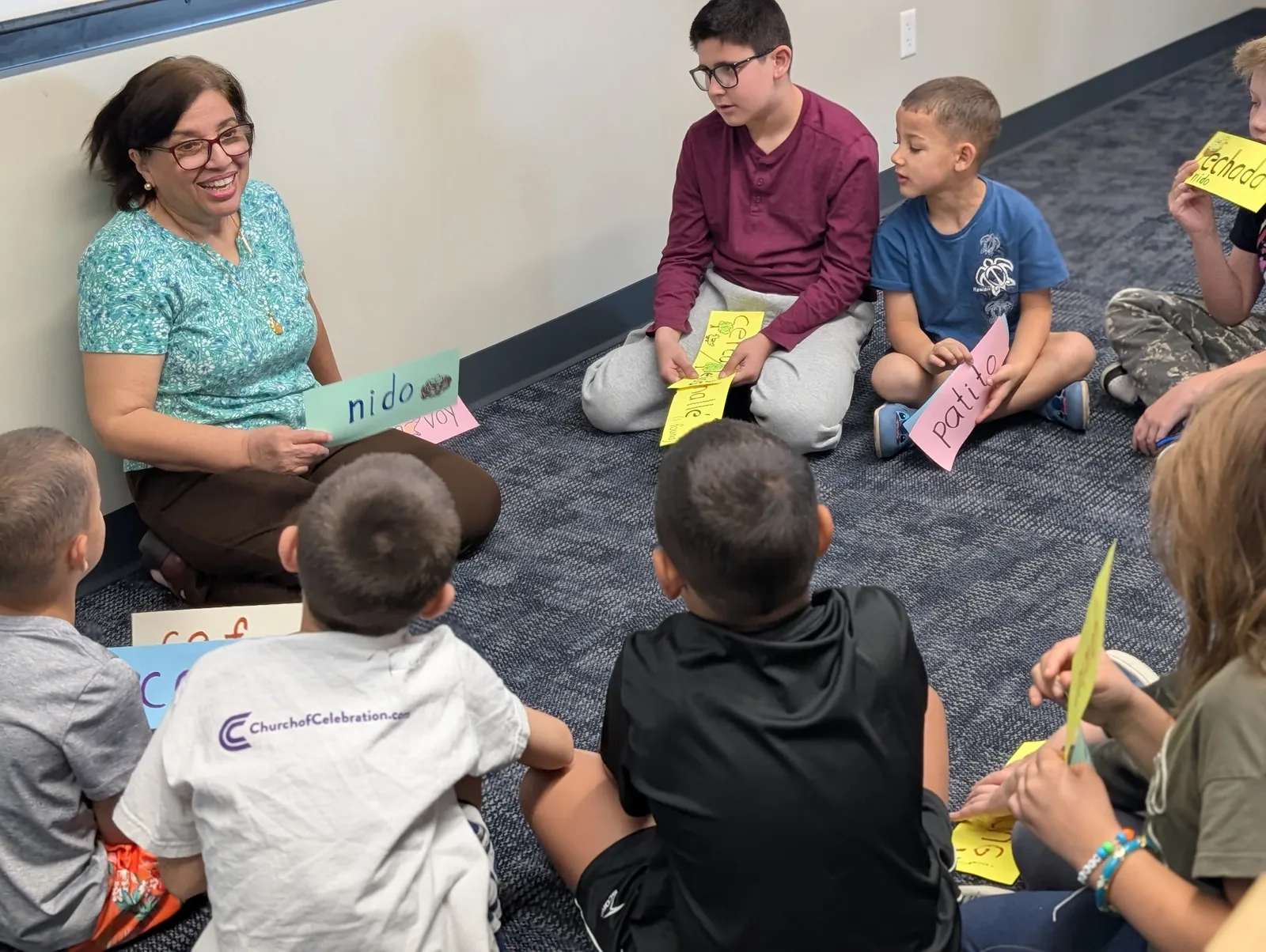 Spanish teacher leading vocabulary flashcard activity with children